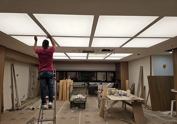 Instalador ajustando o forro luminoso já aceso